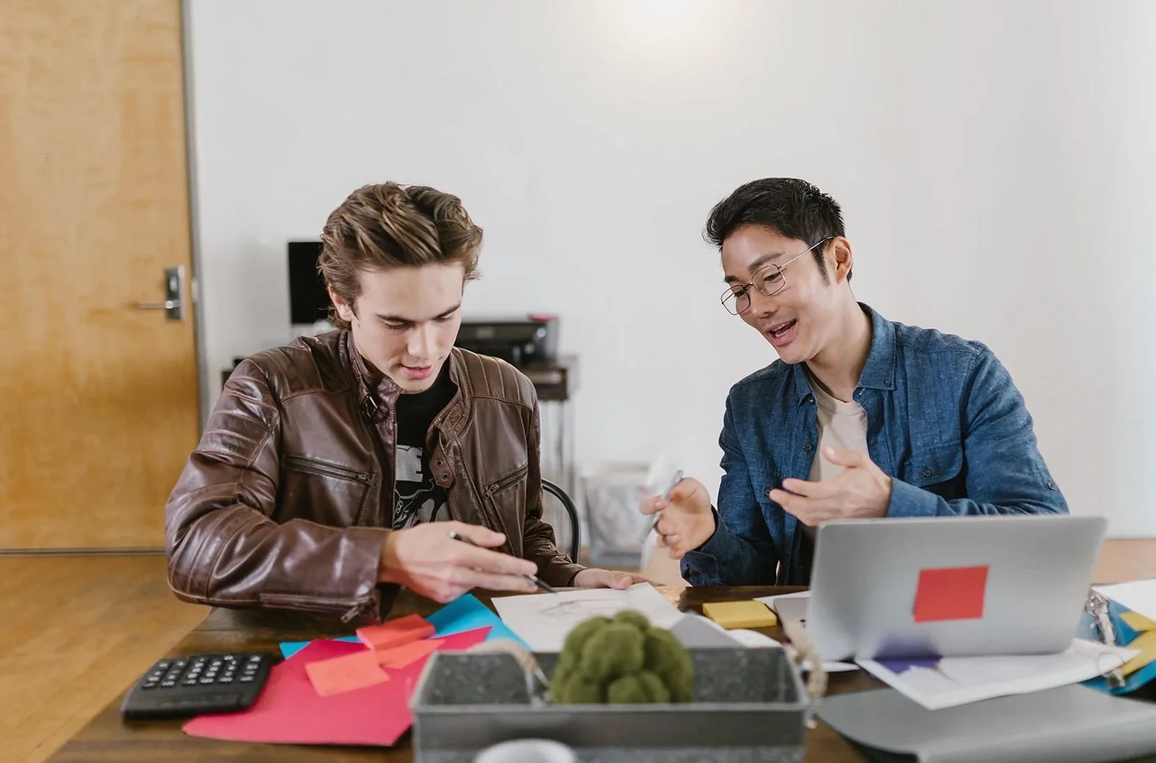 Two business professionals discuss ideas and strategies in an office setting, fostering innovation and teamwork.