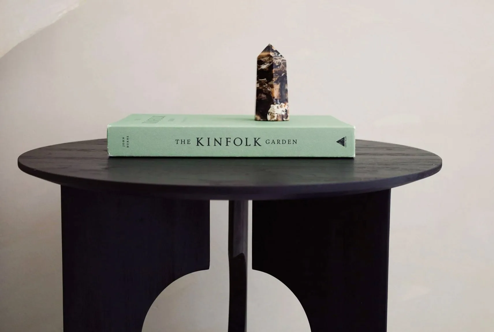 Minimalist interior design featuring a side table with a book and decorative stone, perfect for modern homes.